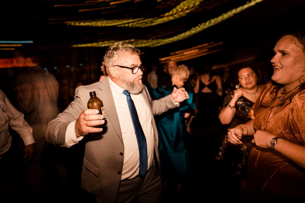 A man in a suit dancing at a party.