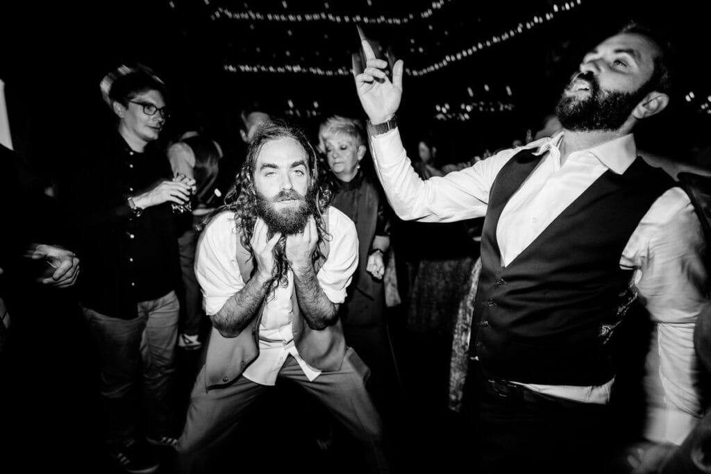 A man with a beard is dancing at a party.