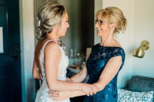 A bride and her mother are getting ready in a hotel room.