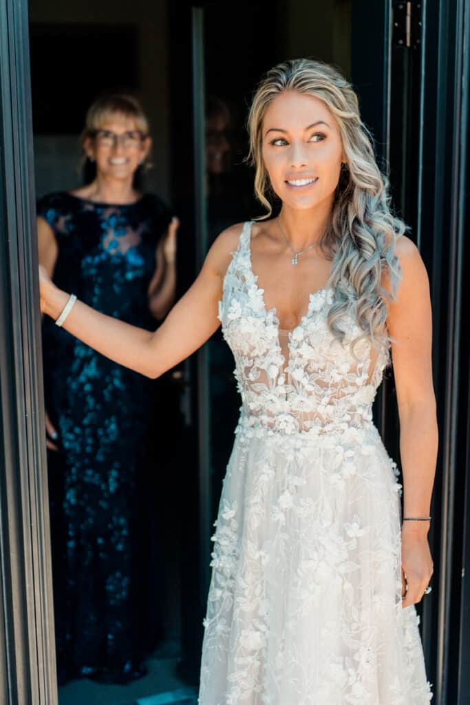A woman in a wedding dress is standing in front of a door.