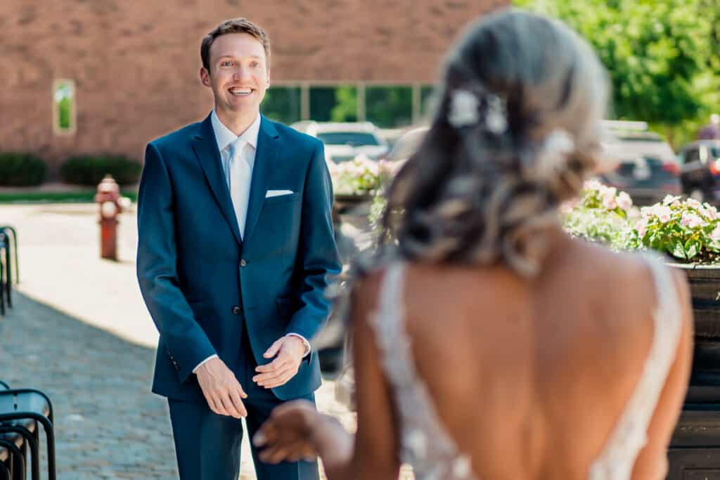 A bride and groom smile at each other as they walk down the aisle.