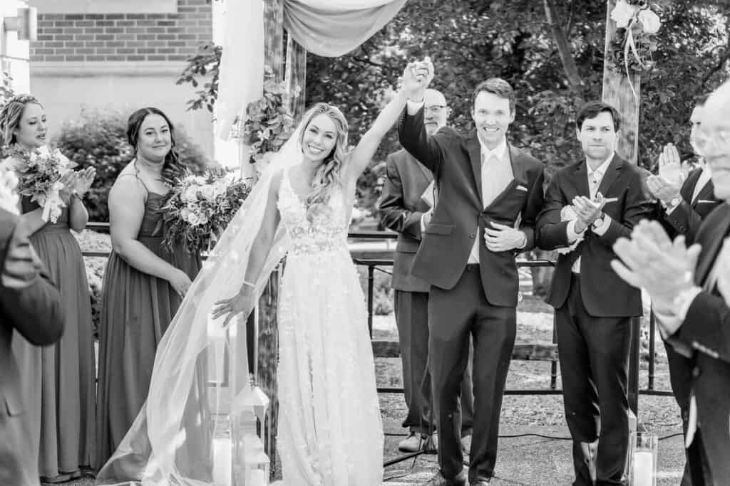 A black and white photo of a bride and groom at their wedding ceremony.