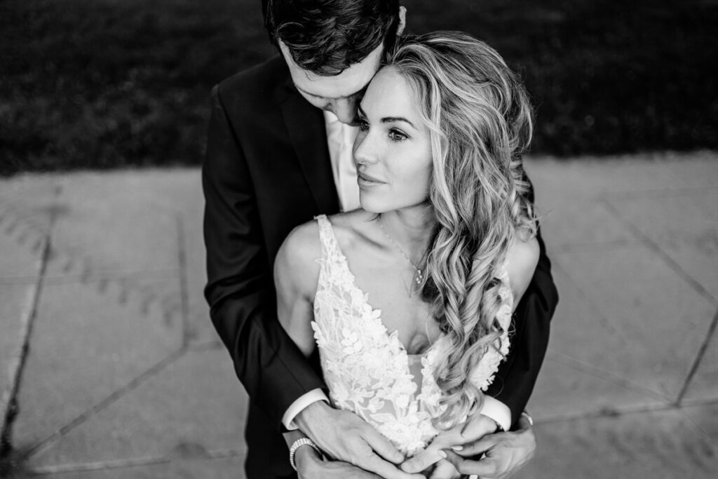 Black and white photo of a bride and groom hugging.