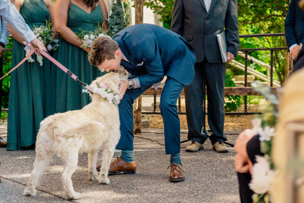 A groom kisses his dog during a wedding ceremony.