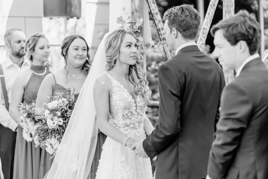 A black and white photo of a bride and groom at their wedding ceremony.