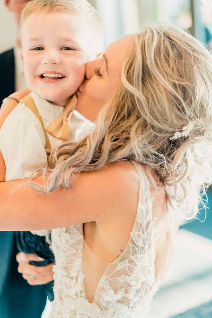 A woman kisses her son during the wedding ceremony.
