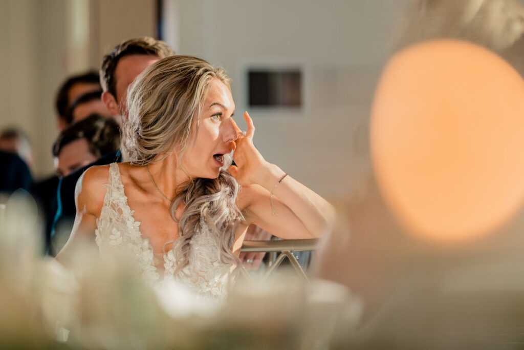 A bride with her mouth open at a wedding reception.