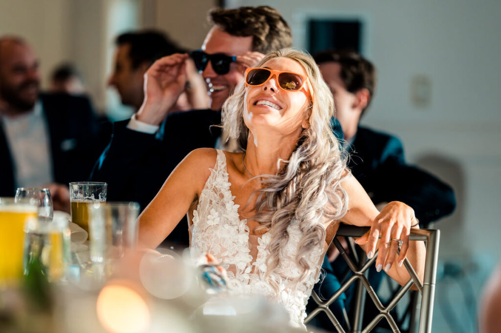 A bride wearing sunglasses at a wedding reception.