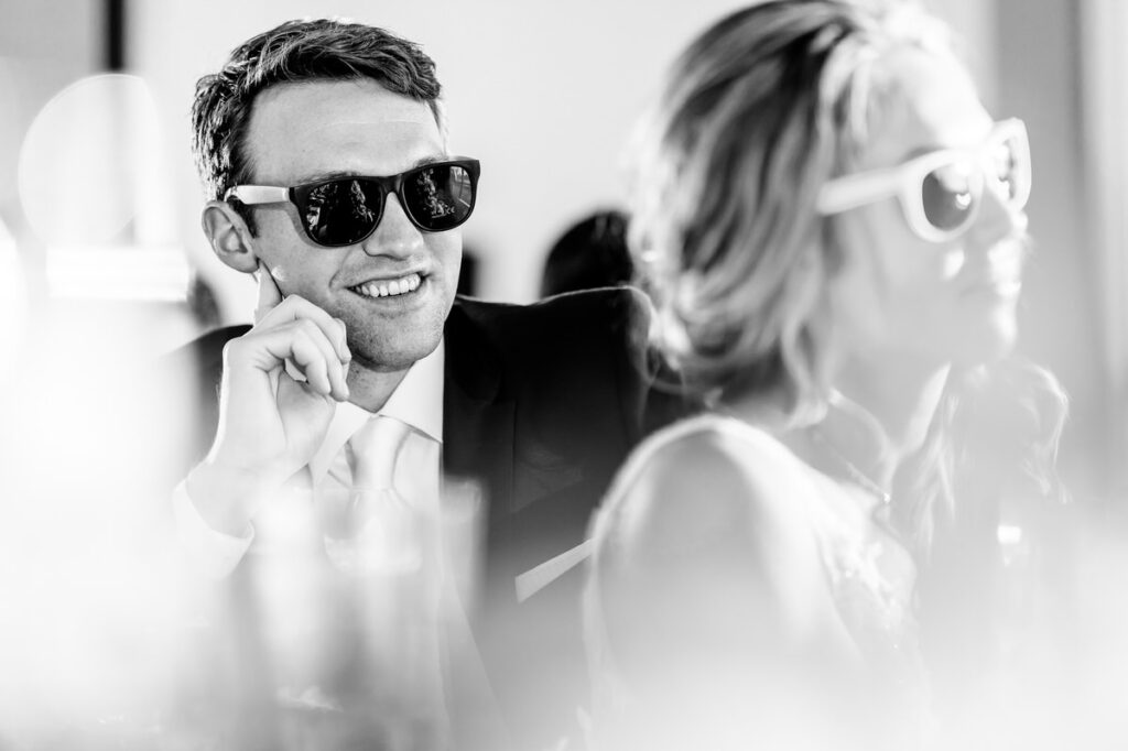 A man and woman wearing sunglasses at a wedding.