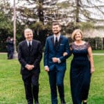 A bride and groom walking down the aisle with their parents.