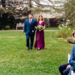 A bride and groom walking down the aisle at an outdoor wedding.