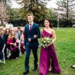 A bride and groom walking down the aisle at an outdoor wedding.