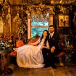 A bride and groom posing in a rustic cabin.