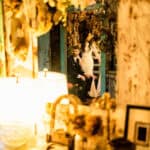 A bride and groom standing in front of a mirror.