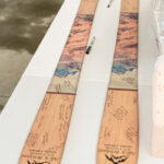Two skis on a table with writing on them.