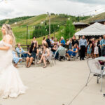 A bride and groom share their first dance at an outdoor wedding.