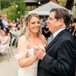 A bride and her father dance at their wedding reception.
