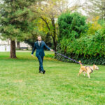A man in a suit walking his dog on a leash.