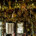A room with a lot of dried flowers hanging from the ceiling.