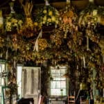 A room with a lot of dried flowers hanging from the ceiling.