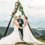 A bride and groom exchange vows in the mountains.