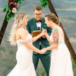 A bride and groom exchanging vows in the mountains.