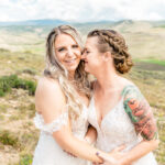 Two brides hugging in the mountains.