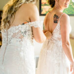 Two brides getting ready in their wedding dresses.