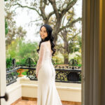 A woman in a wedding dress standing in a doorway.
