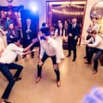 A group of people dancing at a wedding reception.