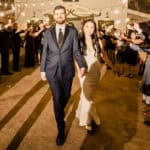 A bride and groom walk down the aisle at a wedding.