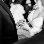 A bride and groom are holding hands during their wedding ceremony.