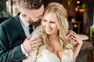 A bride and groom hugging each other in a restaurant.