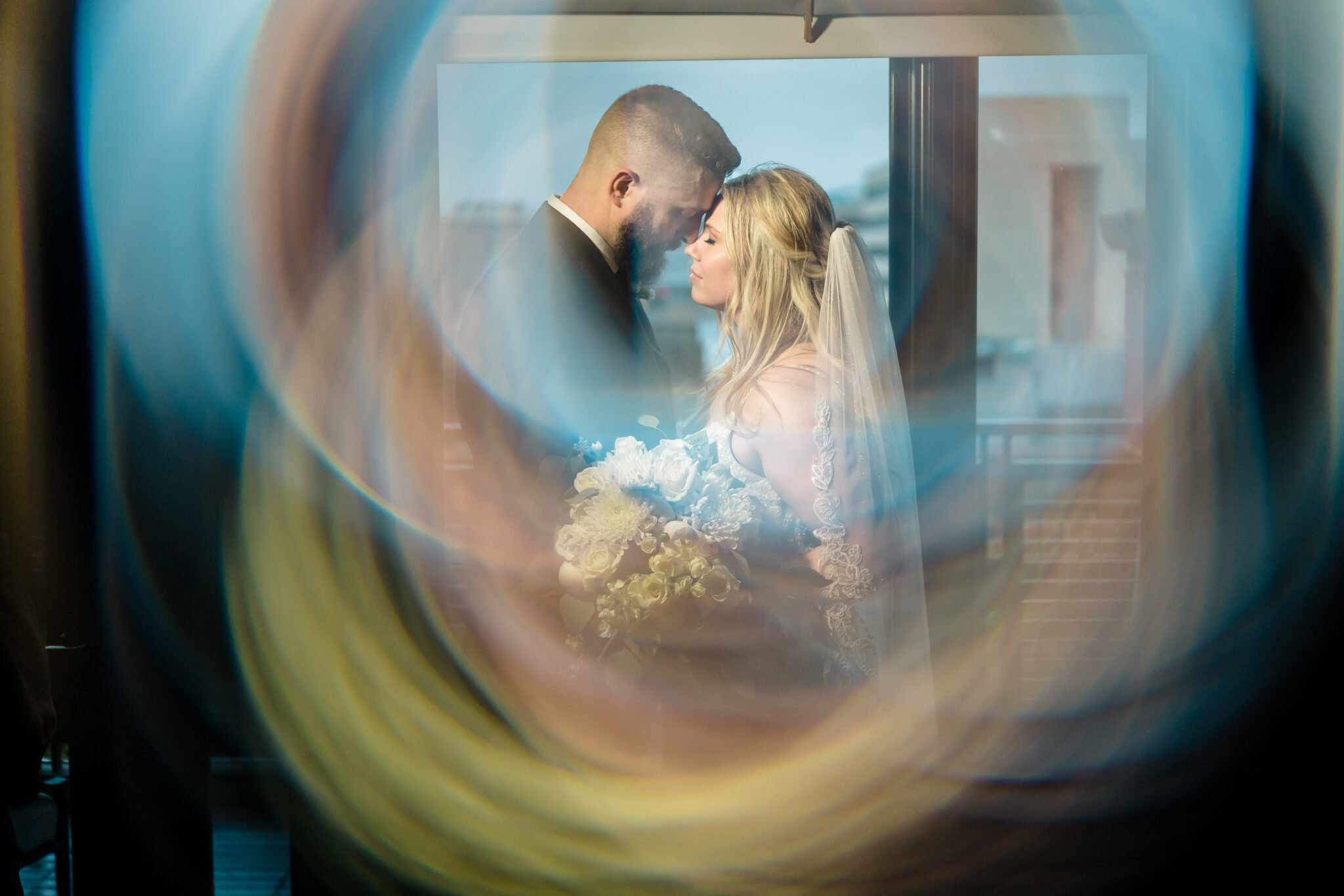 A bride and groom standing in front of a mirror.