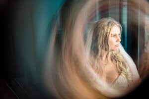 A bride looking at herself through a mirror.