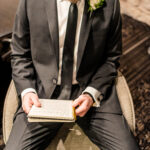 A man in a suit reading a book.