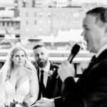 A bride and groom giving a speech at a wedding.