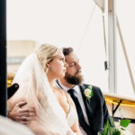 A bride and groom looking at each other on a boat.