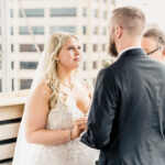 A bride and groom exchange vows on a rooftop.