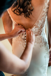 A bride is putting on her wedding dress.