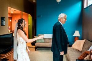 A bride and her father in a living room.