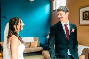 A bride and groom looking at each other in a room.