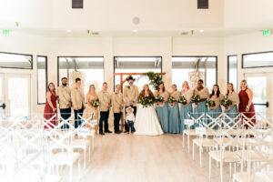 A wedding party posing for a photo in a large room.