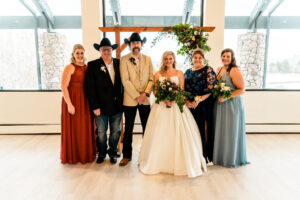 A bride and groom pose for a photo with their wedding party.