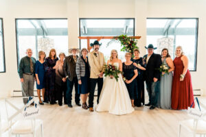 A wedding party posing in front of a large window.