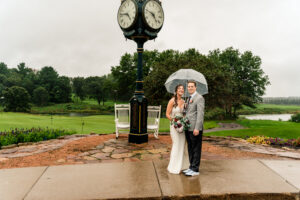 A bride and groom standing in front of a clock.