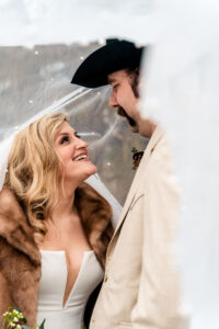 A bride and groom in a cowboy hat and fur.