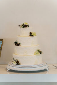 A three tier wedding cake is on display on a table.