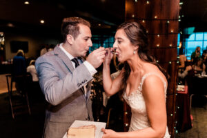 A bride and groom feeding each other cake at a wedding reception.