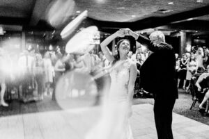 A black and white photo of a bride and her father dancing.